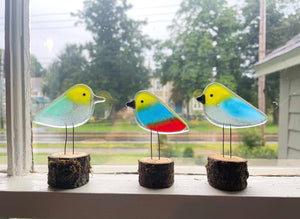 three colourful handcrafted fused glass chicks on a window ledge