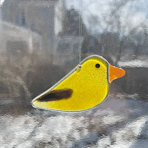Load image into Gallery viewer, Yellow glass goldfinch ornament hanging on a wire with a blurred background