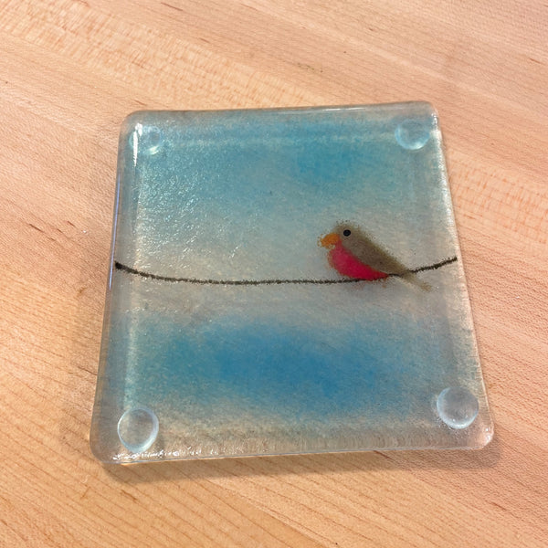 Load image into Gallery viewer, Square glass coaster with a fused glass bird on a wire design, placed on a wooden surface.