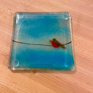 Fused Glass Square glass coaster with a design of a bird on a wire against a blue sky.