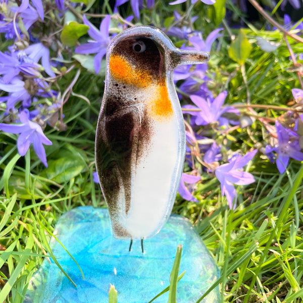 Load image into Gallery viewer, Fused Glass Emperor Penguin on Glass Iceberg in front of purple flowers