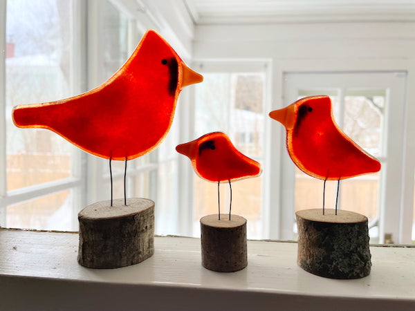 Load image into Gallery viewer, Three different sized perched fused glass red cardinals on log perches, on a window sill.
