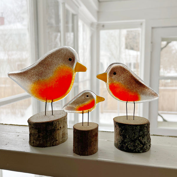 Load image into Gallery viewer, Three glass birds on wooden stands in a bright room with large windows.