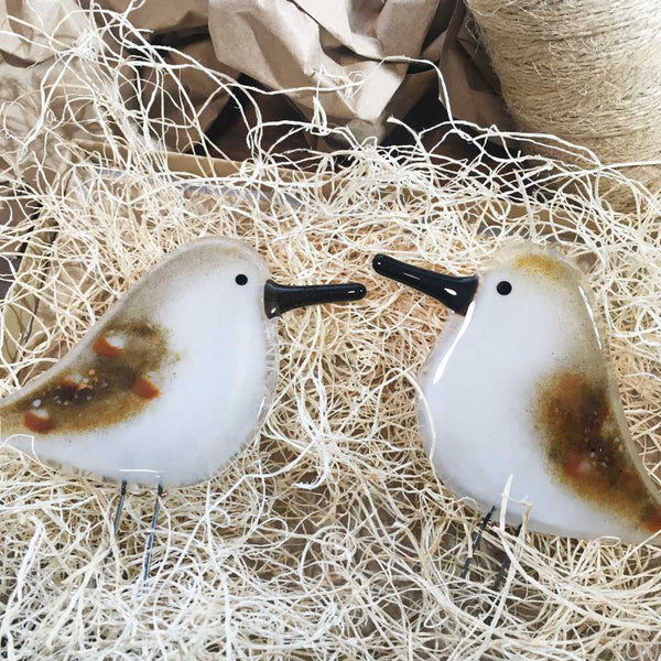 Load image into Gallery viewer, Two brown speckled and white glass birds with long black beaks, shaped to look like sandpipers. The two birds have been placed on wood fibre nesting material.
