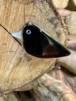 black fused glass hanging crow chick with grey beak, suspended by clear thread