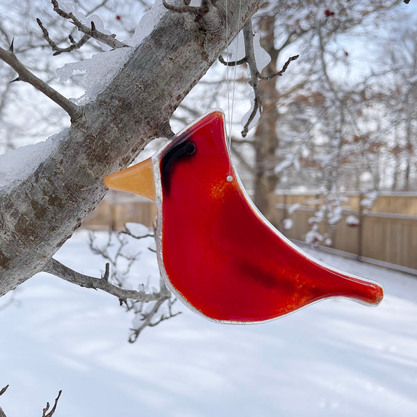 Charger l'image dans la galerie, Red glass cardinal bird ornament hanging from a tree branch in a snowy landscape.