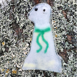 A glass polar bear wearing a green scarf
