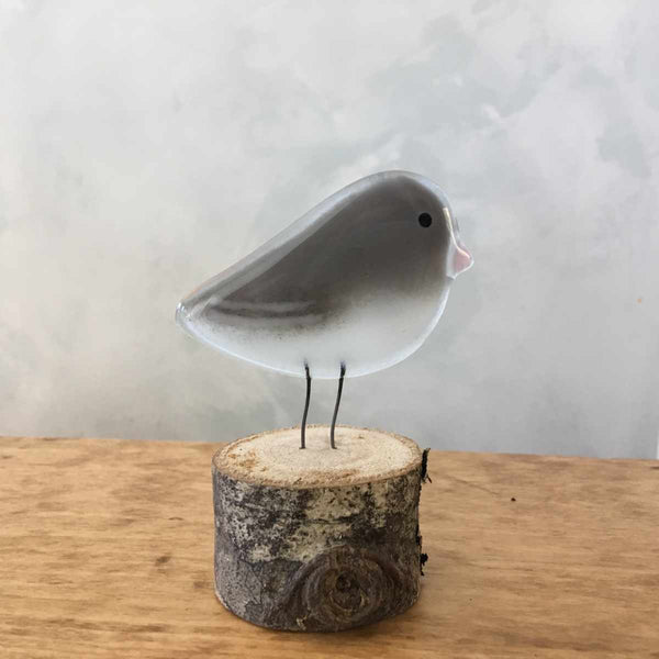 Load image into Gallery viewer, A grey and white glass bird ornament with a pink beak (Dark Eyed Junco).