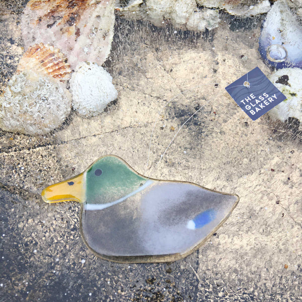 Load image into Gallery viewer, Hanging Glass Mallard Duck Ornament on ice background with seashells.