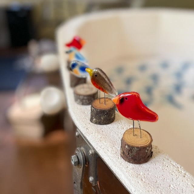Assorted Fused Glass Art Pocket Birds lined up on a kiln wall