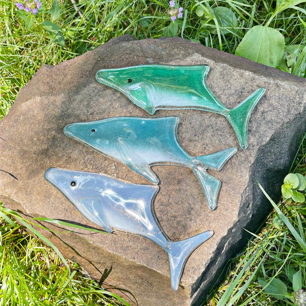 Load image into Gallery viewer, Three fused glass whales are placed on a garden rock
