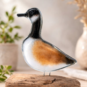 Glass canada goose figurine on a wooden base with a blurred natural background