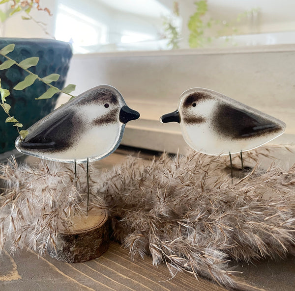 Load image into Gallery viewer, Two decorative chickadee bird figures on stands in a cozy feel habitat on a shelf
