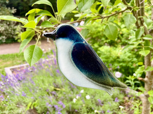 Deep Blue and White Fused Glass Tree Swallow Ornament Hanging in the Backyard Garden