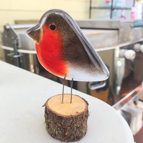 Fused Glass Brown and Red British Robin Chick perched on a wood slice, in a glass fusing studio