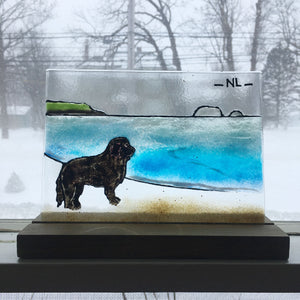 A fused glass picture painting tile featuring a Newfoundland dog on a beach