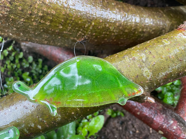 Load image into Gallery viewer, A fused glass painted turtle lays on top of branches.
