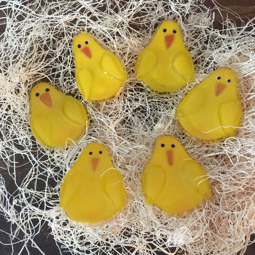 Six Fused Glass Yellow Chicks sit in a wood fibre nest