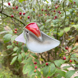 handcrafted fused glass junco in a red hat