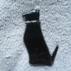 Black glass dog with a white moustache and purple collar. 