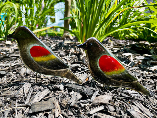 Load image into Gallery viewer, Two decorative birds with red and yellow spots on a mulched garden bed.
