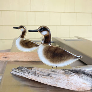Two fused glass canada goose bird figurines on a wooden base with a neutral background