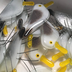 a bunch of fused glass seagull chicks