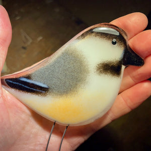 glass chickadee bird in the hand