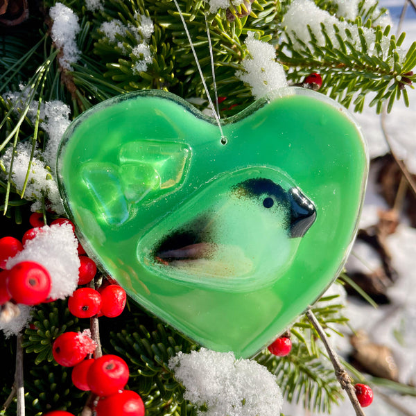 Load image into Gallery viewer, Heart-shaped green ornament with a bird design on a snowy branch with red berries
