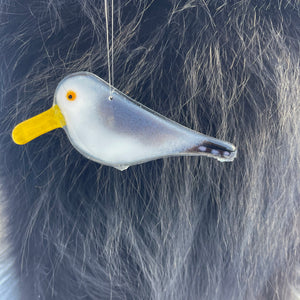 Glass seagull ornament hanging on a dark fur surface