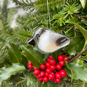 Fused Glass chickadee bird ornament hanging among greenery and red berries