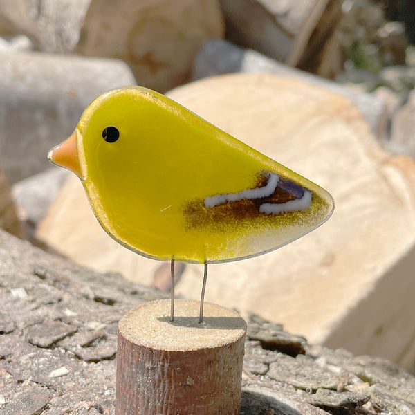 Load image into Gallery viewer, Yellow glass bird ornament on a wooden stand with a natural stone background
