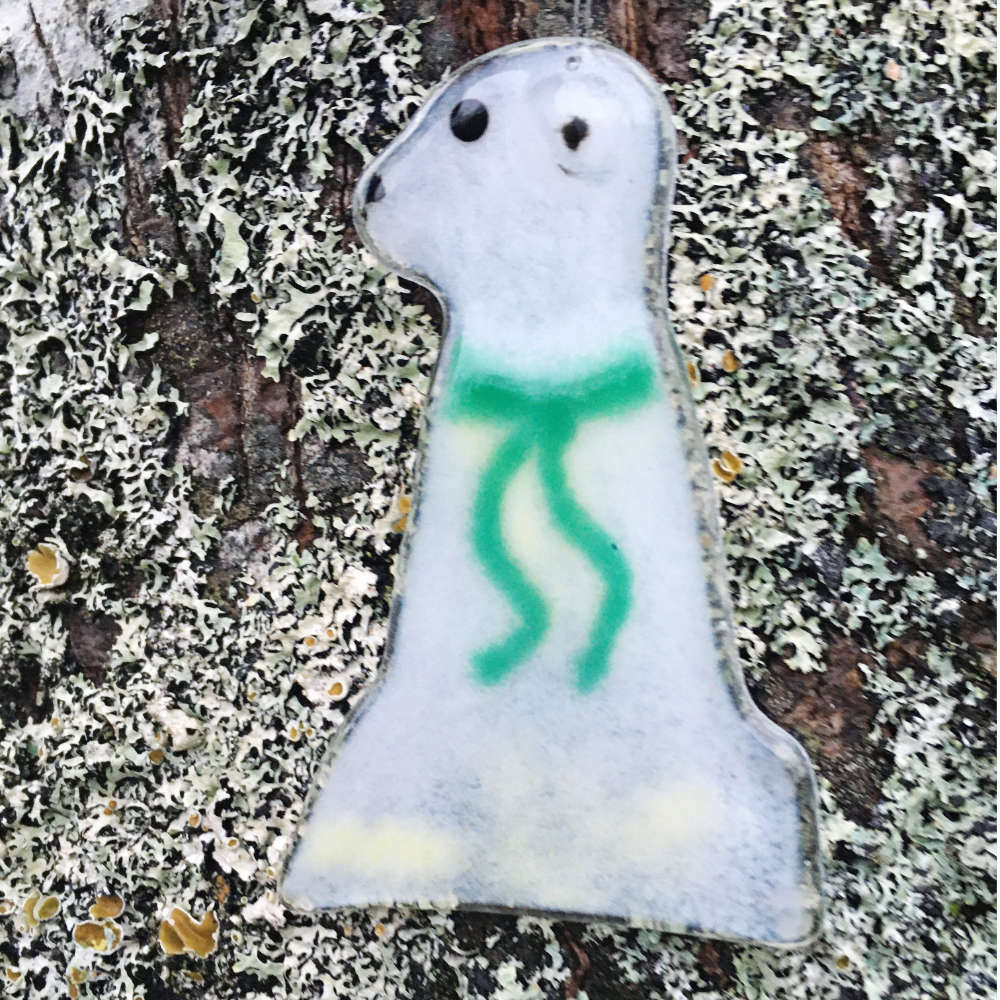 A glass polar bear wearing a green scarf