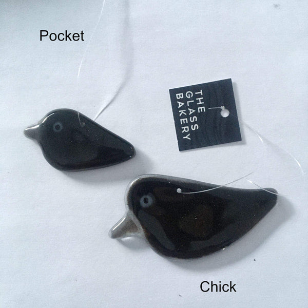 Load image into Gallery viewer, Two black hanging glass ornamental crows of different sizes.
