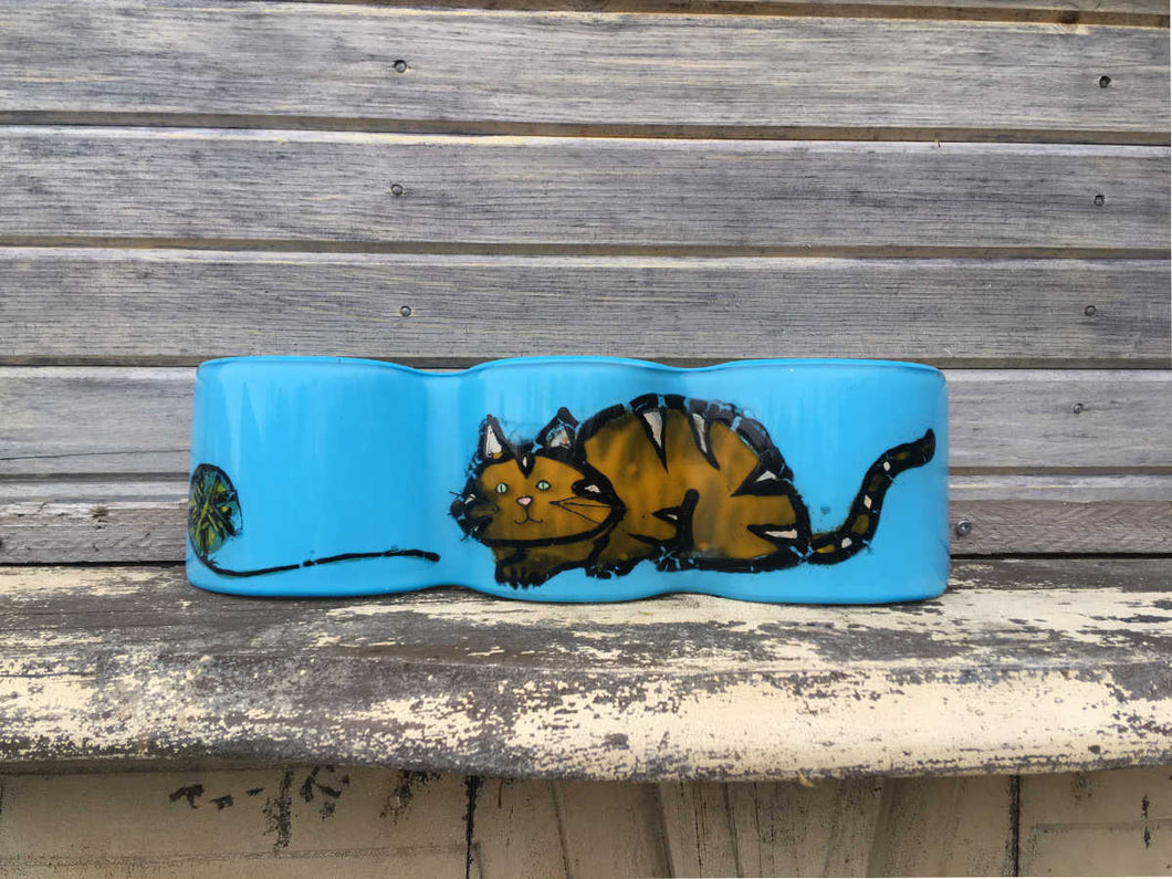 Aqua wave of glass with orange and gold coloured tabby cat