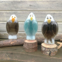 Load image into Gallery viewer, Three glass eagles stand on logs. Two are brown eagles and they flag a blue eagle
