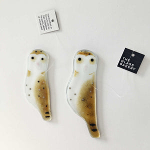 Two different sized brown speckled glass owl bird ornaments with a white chest. The birds are placed on a white background.