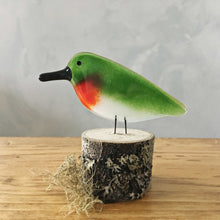 Load image into Gallery viewer, A red, green and white ruby throated hummingbird made of glass is perched on a lichen covered log.
