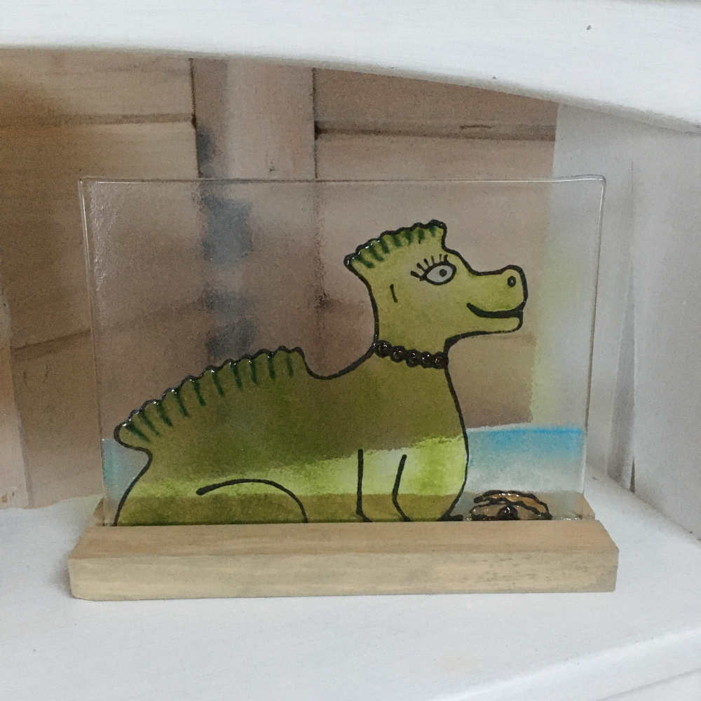 Glass picture featuring Nessie wearing a string of purple purples