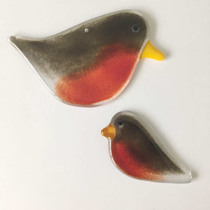 Two brown and red glass robin bird ornaments are displayed laying on a white background