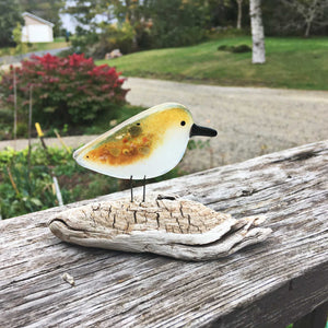 Brown and white speckled pattern glass bird on driftwood