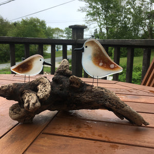 Pair of glass sandpipers on driftwood.