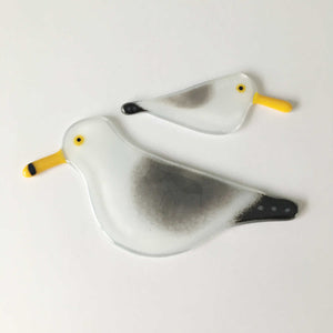 Two glass black, grey and white birds with yellow beaks, created to look like Gulls