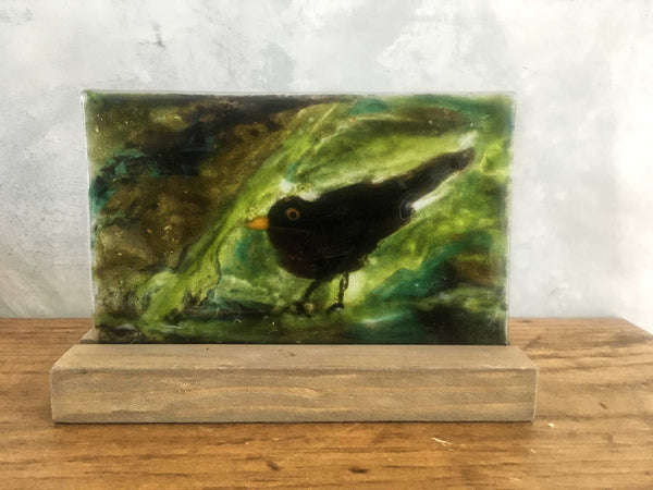 Load image into Gallery viewer, blackbird in a bush - glass picture tile with slotted pine stand
