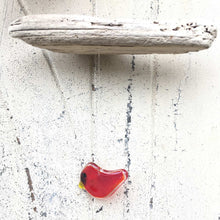 Load image into Gallery viewer, a small red glass cardinal ornament hangs from a piece of driftwood.
