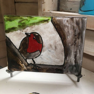 Glass picture of a robin. Mounted on an iron stand.